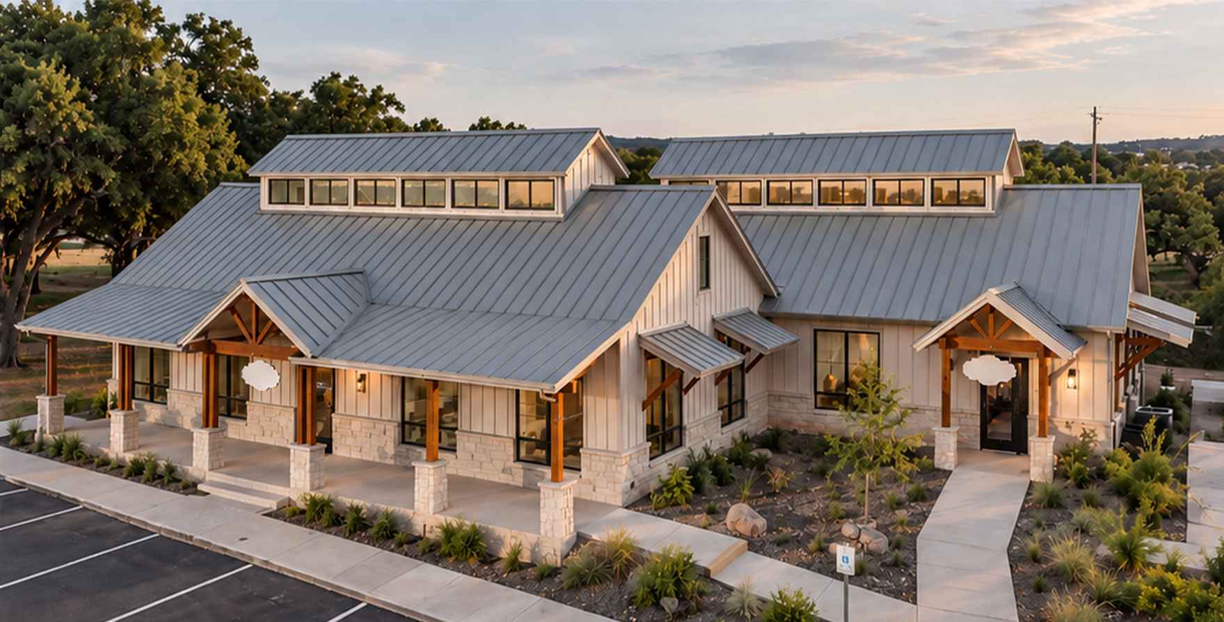 Texas Hill Country commercial building with a prominent standing-seam metal roof in soft warm evening light